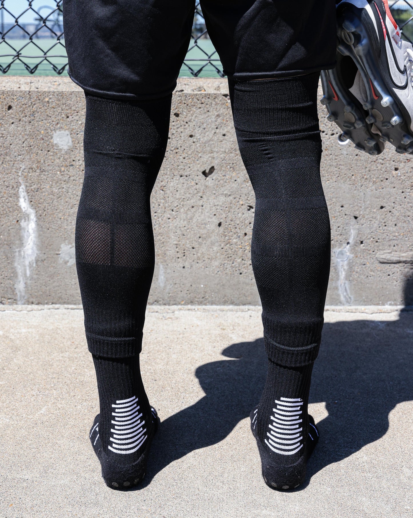 SL PRO Grip Socks Black Back View Standing No Cleats, with Sleeves
